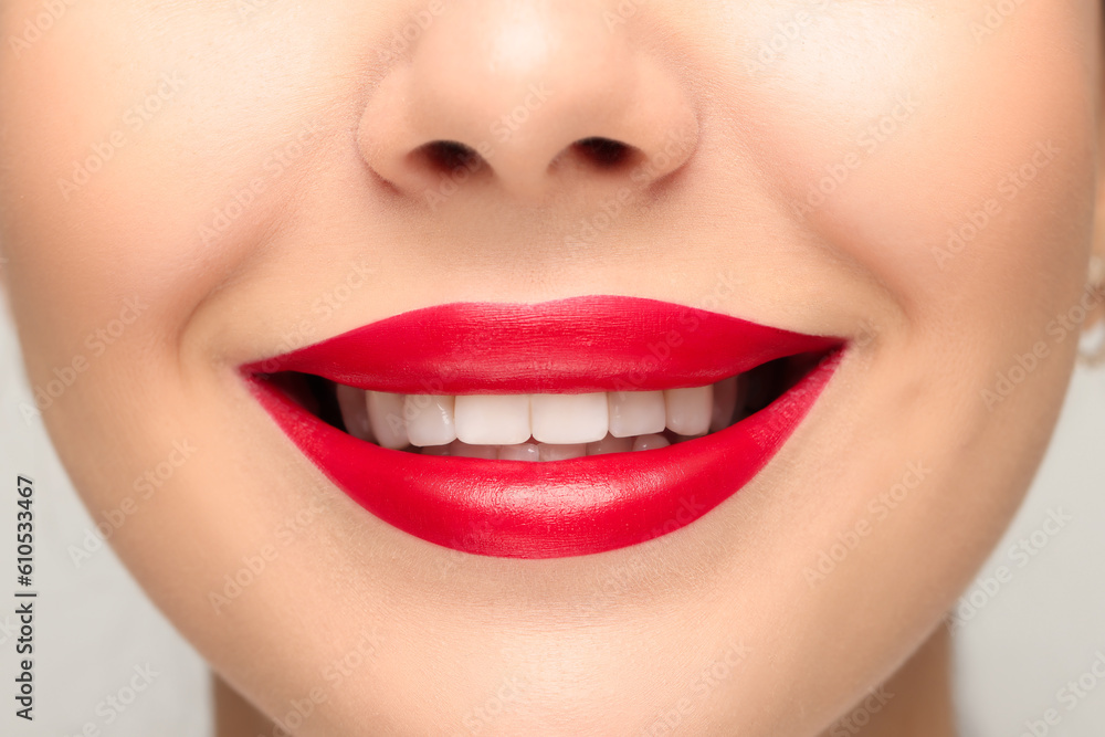 Obraz premium Smiling woman with healthy teeth on light background, closeup