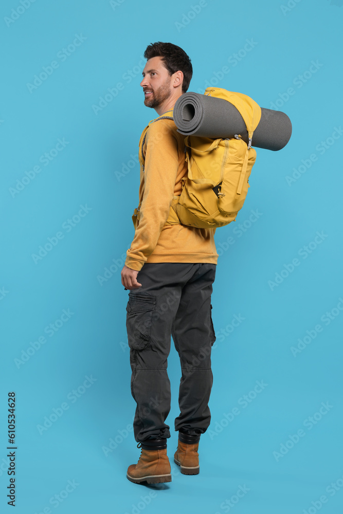 Naklejka premium Man with backpack on light blue background. Active tourism
