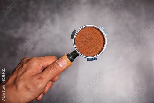 Hands hold portafilter with ground coffee for espresso coffee maker 
