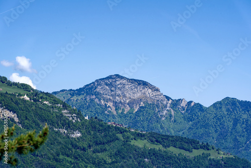 Beautiful mountain panorama with woodland  peak and Seelisberg village in the Swiss Alps at lakeshore of Lake Lucerne on a sunny spring morning. Photo taken May 22nd  2023  Sisikon  Switzerland.
