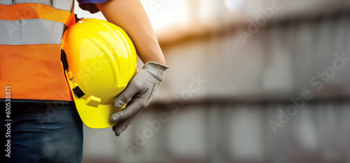 Construction worker or builder holding yellow hard hat, closeup detail to hand in protective gloves and helmet. Generative AI