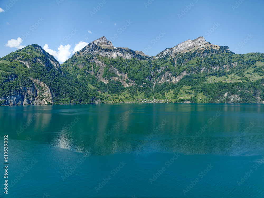 View of Lake Uri with beautiful mountain panorama and village Bauen on a sunny spring day. Photo taken May 22nd, 2023, Sisikon, Switzerland.