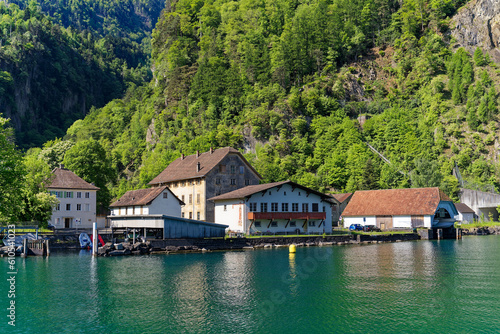 View of Lake Uri with beautiful mountain panorama and pier at village Bauen on a sunny spring day. Photo taken May 22nd, 2023, Bauen, Switzerland.
