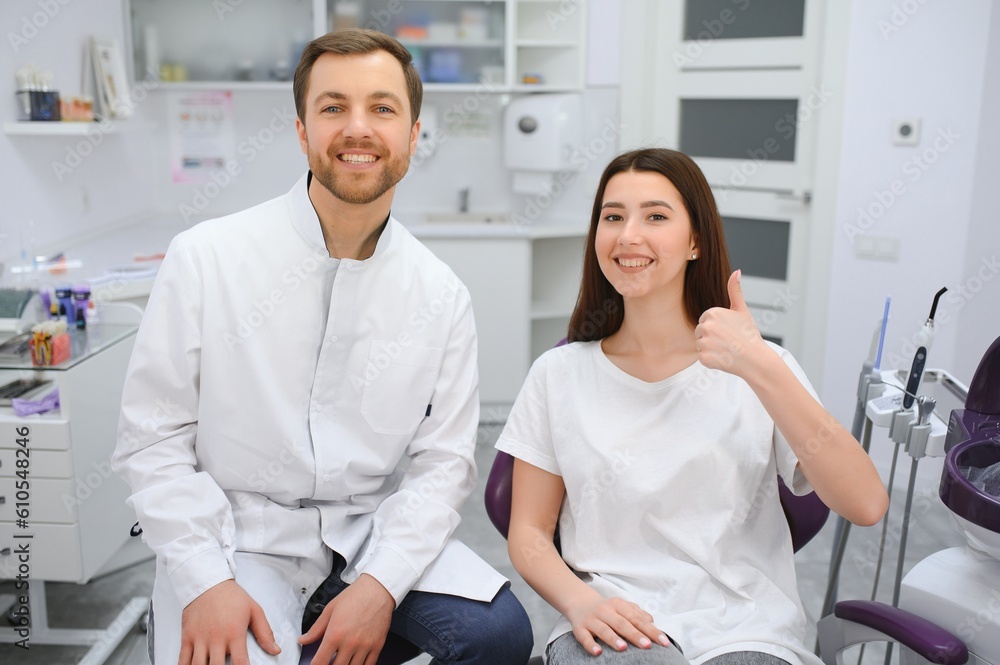 people, medicine, stomatology and health care concept - woman patient talking to male dentist and complain of toothache at dental clinic office. people, medicine, stomatology and health care concept - woman patient talking to male dentist and complain of toothache at dental clinic office.