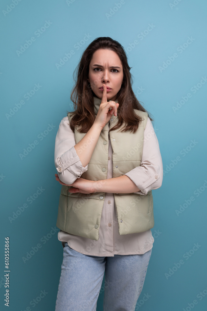 upset concentrated brunette young woman in vest and shirt in studio upset concentrated brunette young woman in vest and shirt in studio