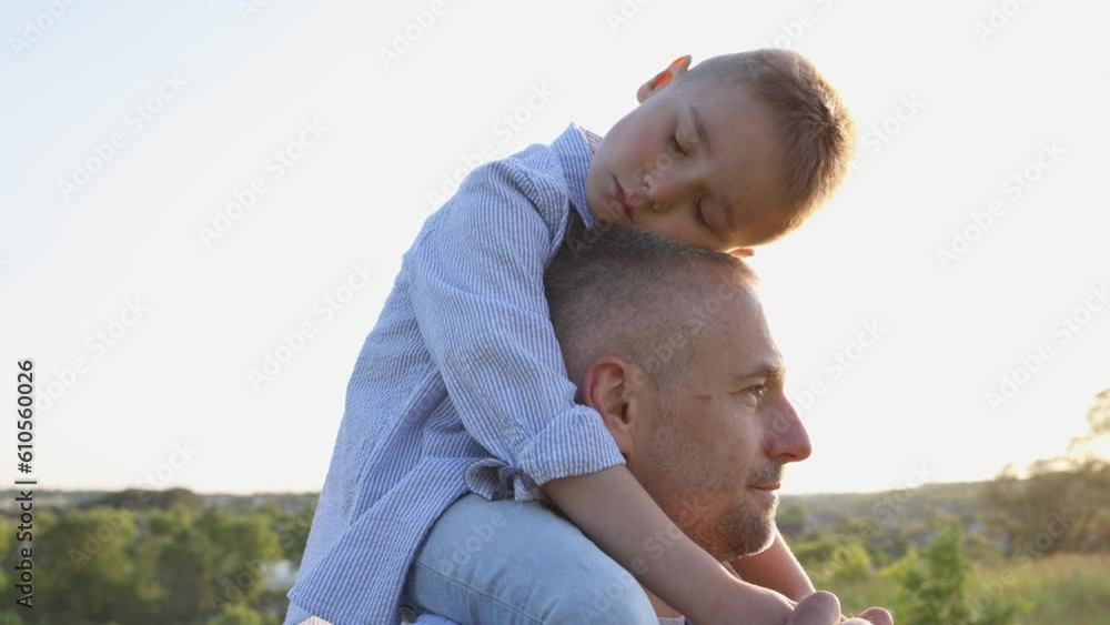 Happy child embraces his father outdoor. Portrait of a happy child. Family time. Dad and son outdoor. Family in the sun at sunset. Footage in slow motion 4K Happy child embraces his father outdoor. Portrait of a happy child. Family time. Dad and son outdoor. Family in the sun at sunset. Footage in slow motion 4K