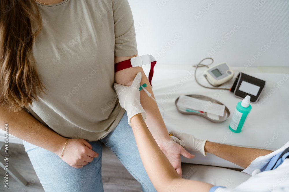High angle view of doctor removing blood from patient's arm in clinic High angle view of doctor removing blood from patient's arm in clinic