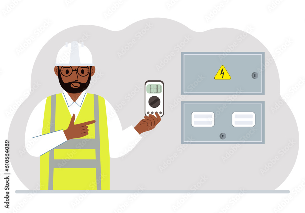 A male electrical engineer holds a digital multimeter in his hand and stands next to an electrical cabinet. A male electrical engineer holds a digital multimeter in his hand and stands next to an electrical cabinet.