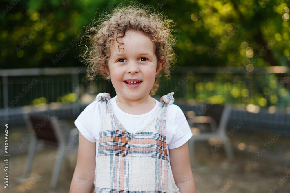 Sweet little girl with curly hair outdoors in the park Sweet little girl with curly hair outdoors in the park