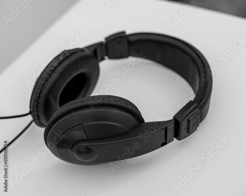 Black wireless over-ear headphones on light wooden background.