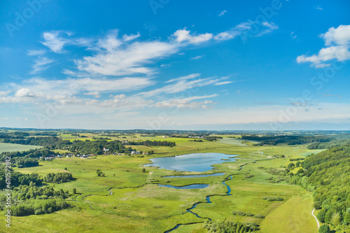 Nature, lake and environment with drone of countryside for agriculture, farming and summer. Grass, travel and landscape with aerial view of meadow field and blue sky for growth, plants and ecology