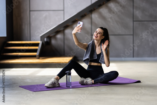 Young attractive woman break pause sit mat make selfie cellphone sportswear home