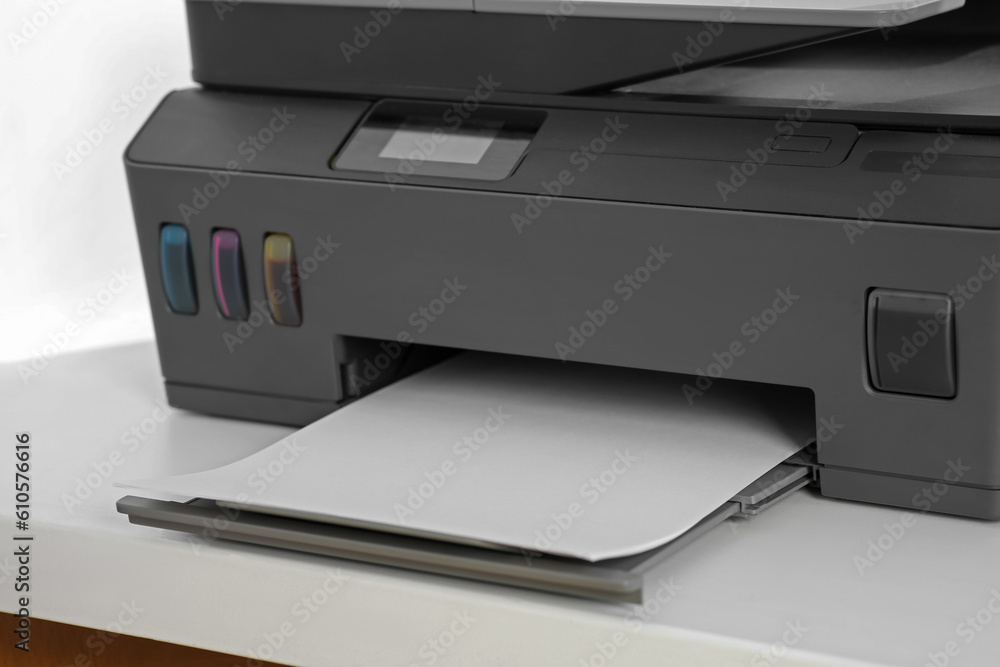 Modern printer with paper on white table, closeup Modern printer with paper on white table, closeup