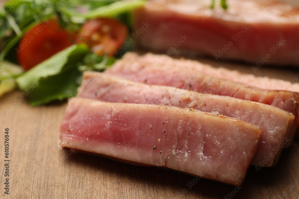 Pieces of delicious tuna steak on wooden board, closeup Pieces of delicious tuna steak on wooden board, closeup