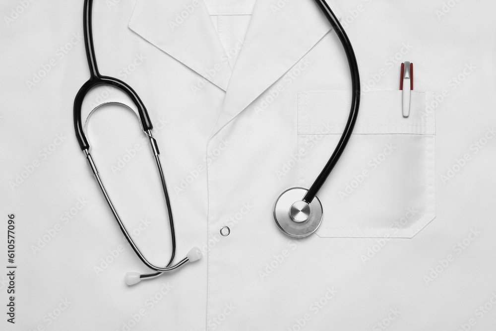 Stethoscope on white medical uniform, top view