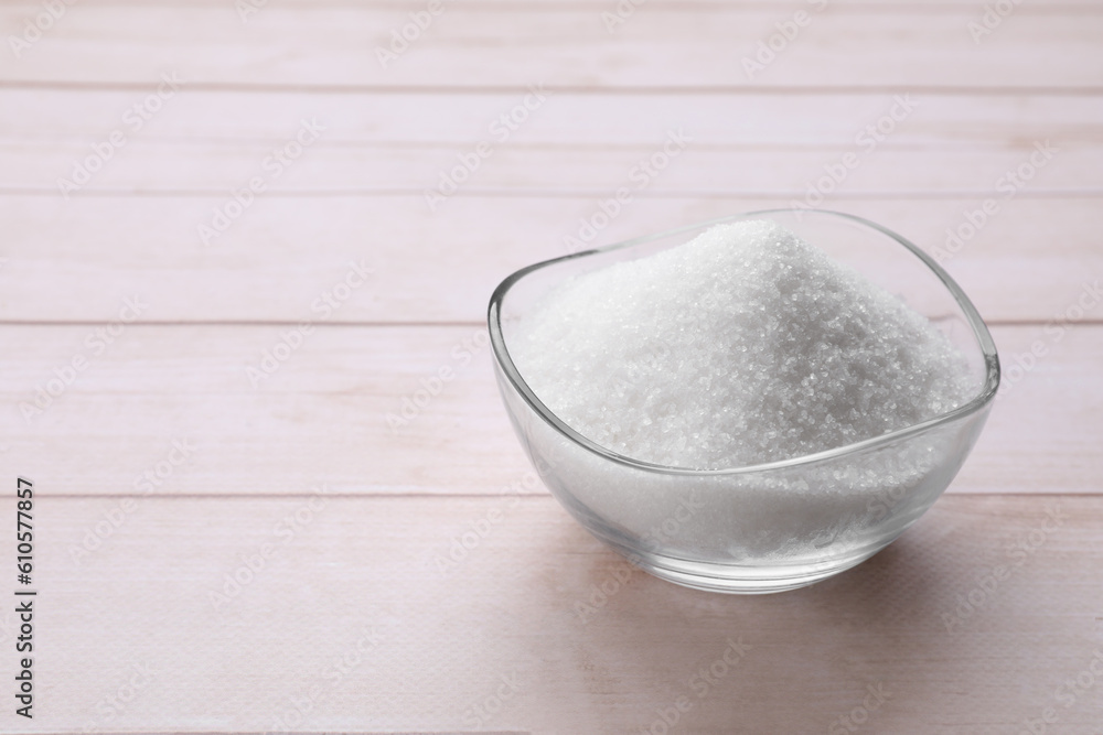 Granulated white sugar in bowl on wooden table, closeup. Space for text Granulated white sugar in bowl on wooden table, closeup. Space for text
