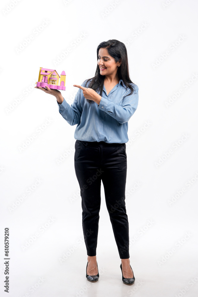 Indian woman holding home toy in hand. real estate concept. Indian woman holding home toy in hand. real estate concept.