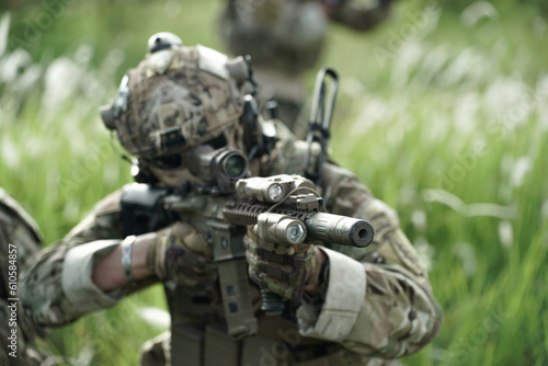 Army elite troops marksman, special operations forces sniper wearing mask and glasses, night-vision or infrared thermal imaging device on helmet, holding service rifle with optical sight and silencer