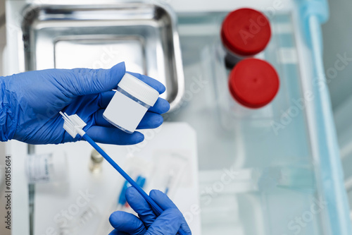 Gynecologist is holding flask for cytology Pap smear test in hands. Gynecological cytology Pap smear test and cytobrush in hands of gynecologist. photo