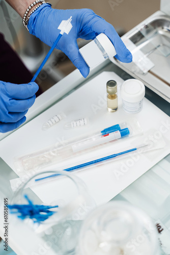 Gynecologist is holding flask for cytology Pap smear test in hands. Gynecological cytology Pap smear test and cytobrush in hands of gynecologist. photo