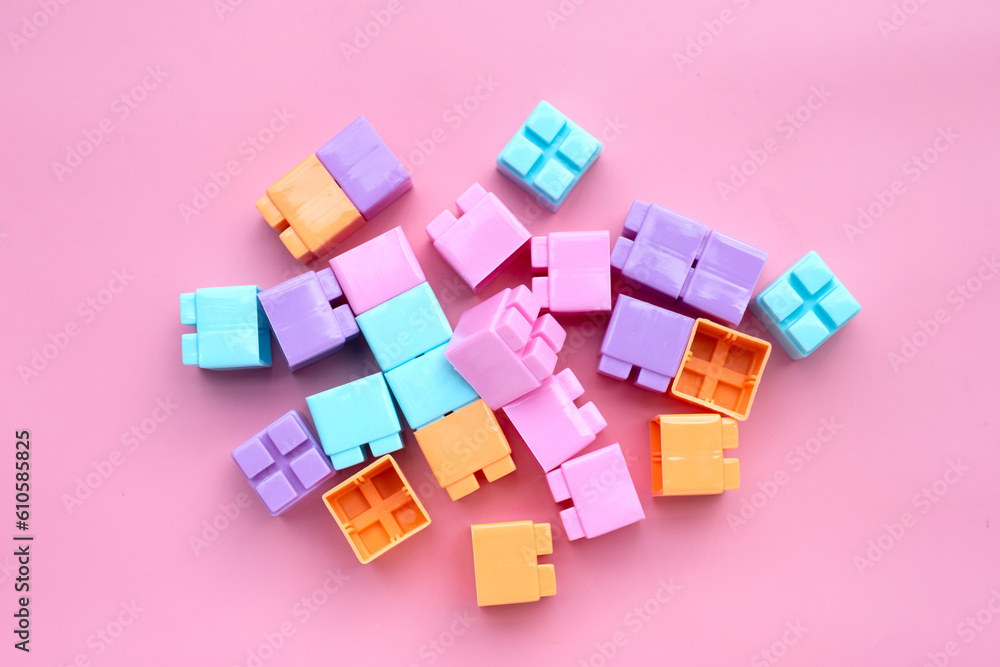 Obraz premium Plastic building blocks isolated on pink background. Top view