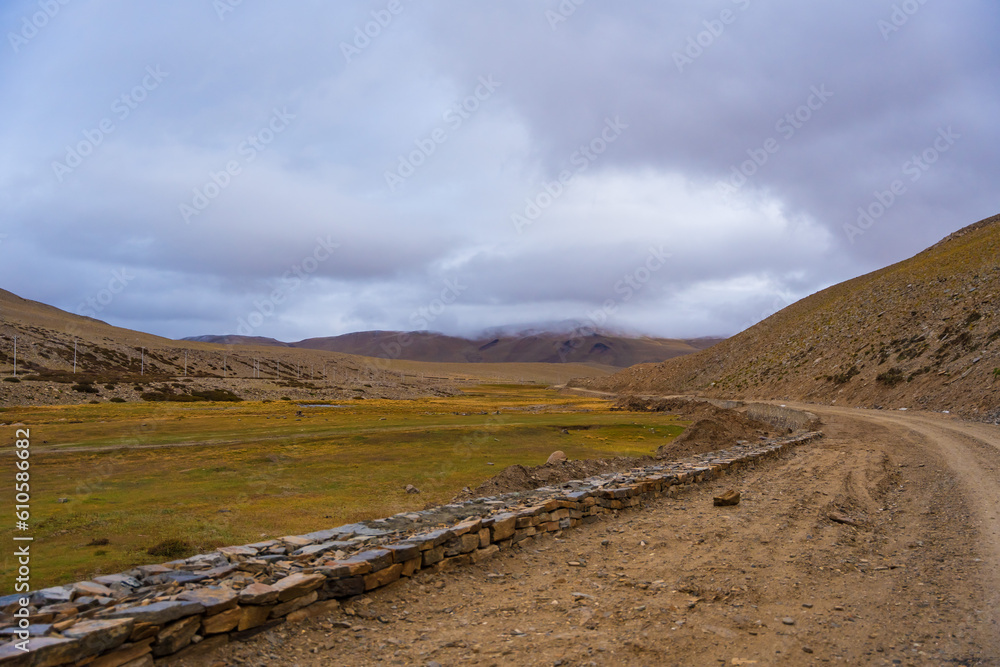 withered grass field, the mountain and cloud sky at Tso Kar lake, Beautiful scenery along the way at Ladakh, India. The Tso Kar or Tsho kar is a fluctuating salt lake withered grass field, the mountain and cloud sky at Tso Kar lake, Beautiful scenery along the way at Ladakh, India. The Tso Kar or Tsho kar is a fluctuating salt lake