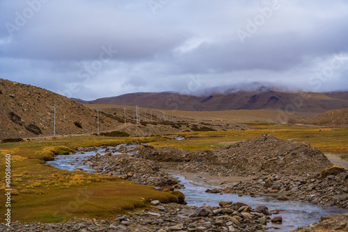 A small stream flows through the grassy fields at the foot of the mountain near Tso Kar, Thukje, Ladakh, India
