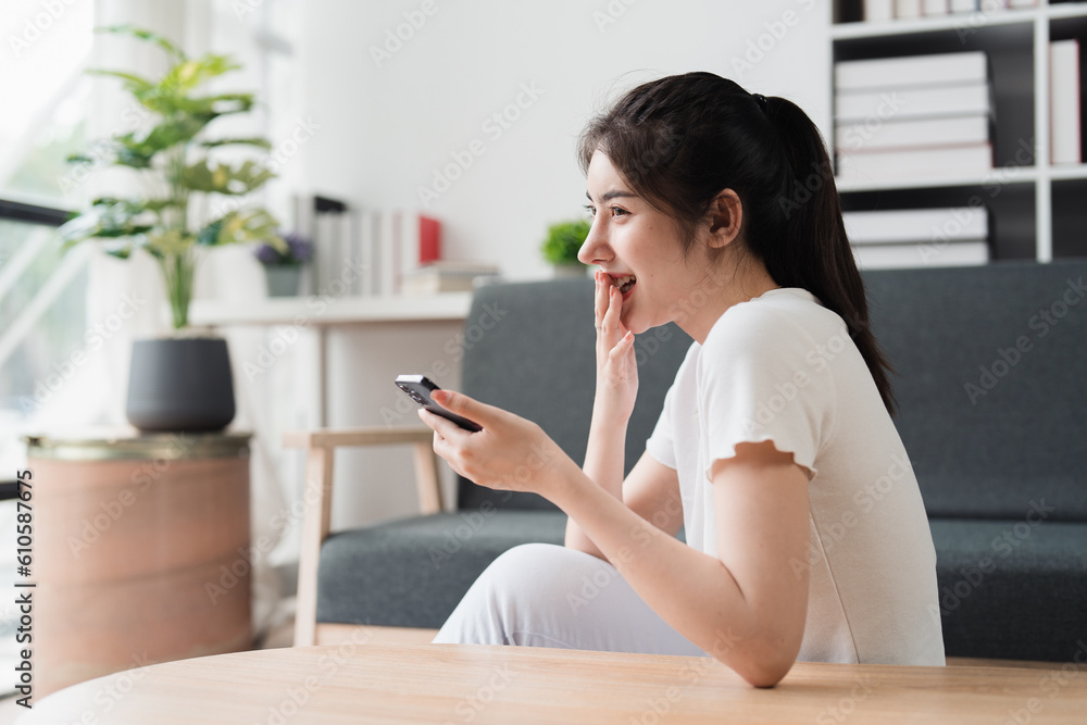 Young relaxed smiling pretty woman relaxing sitting on sofa at home. Female feeling joy enjoying with mobile phone on cozy couch Young relaxed smiling pretty woman relaxing sitting on sofa at home. Female feeling joy enjoying with mobile phone on cozy couch