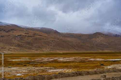 withered grass field, the mountain and cloud sky at Tso Kar lake, Beautiful scenery along the way at Ladakh, India. The Tso Kar or Tsho kar is a fluctuating salt lake