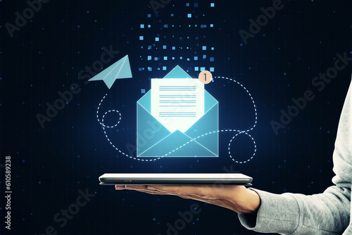 Mail application, email and communication concept with paper list in envelope with red notification alert symbol above man hand palm with digital tablet on abstract dark background photo