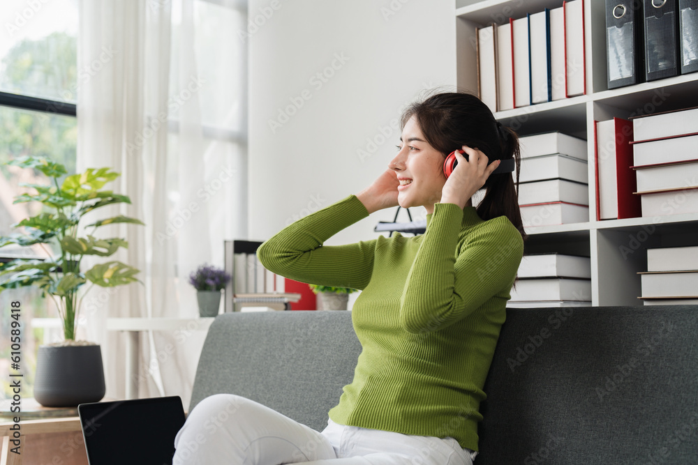 Young relaxed smiling pretty woman relaxing sitting on sofa at home. Female feeling joy enjoying with music on cozy couch Young relaxed smiling pretty woman relaxing sitting on sofa at home. Female feeling joy enjoying with music on cozy couch
