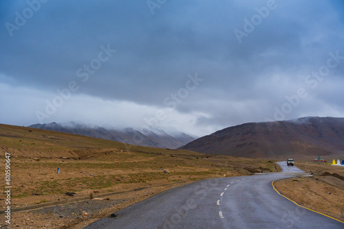 car on the road, mountain and cloud sky at Tanglang La pass in Ladakh, India, is the second highest motorable road in the world at 5400m photo