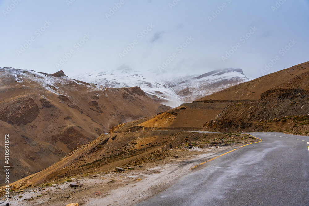 The road, Snow covered mountains, cloudy sky at Taglang La Pass, Keylong-Leh Road, the way from Moriri lake to Manali town, Ladakh, India