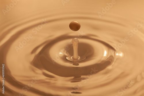 Falling drop into water. Frozen drop of milk, splash and waves and circles on the surface