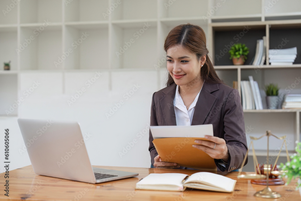female lawyers working on laptop and contract documents at the law firms. Judge with scales of justice. Legal law, lawyer, advice and justice concept female lawyers working on laptop and contract documents at the law firms. Judge with scales of justice. Legal law, lawyer, advice and justice concept