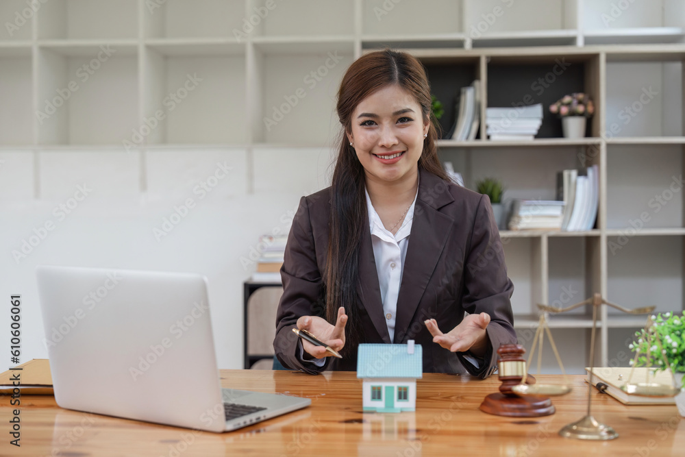 Beautiful Asian woman lawyer work on real estate loan contract example home of a mallet with a laptop placed at the office Beautiful Asian woman lawyer work on real estate loan contract example home of a mallet with a laptop placed at the office