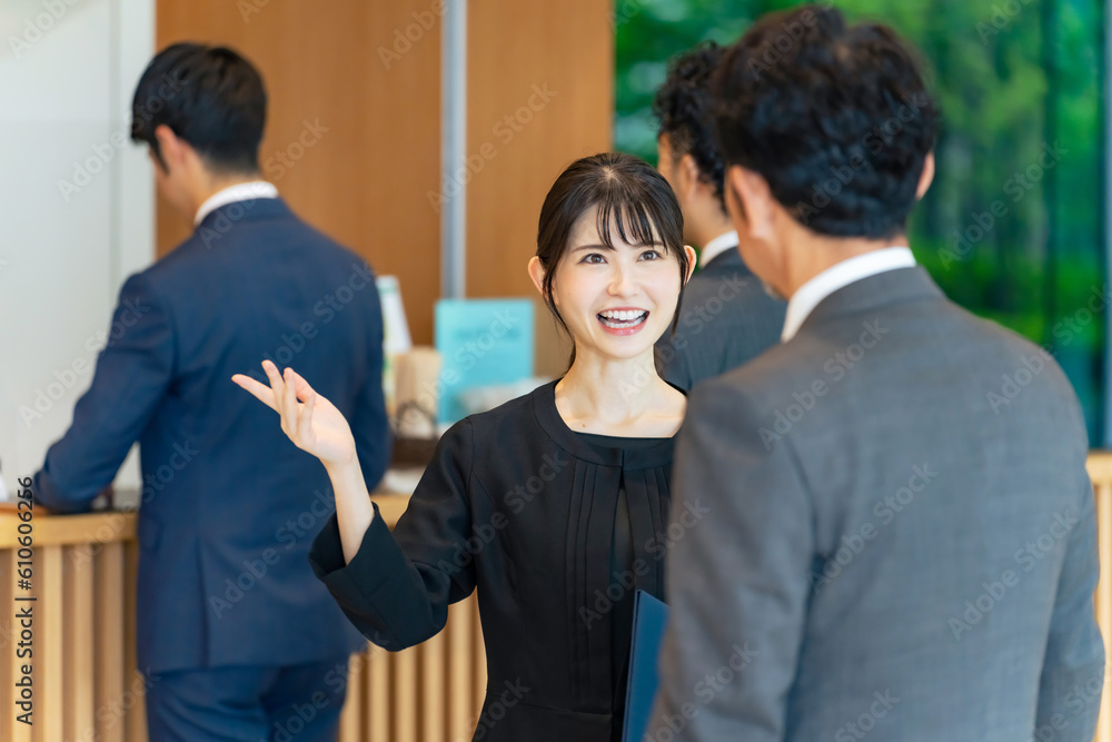 フロントで旅行客を接客する案内係の女性 フロントで旅行客を接客する案内係の女性