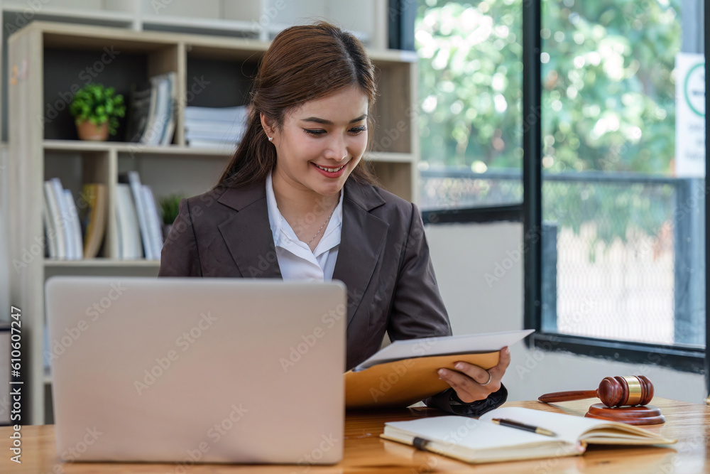 female lawyers working on laptop and contract documents at the law firms. Judge with scales of justice. Legal law, lawyer, advice and justice concept female lawyers working on laptop and contract documents at the law firms. Judge with scales of justice. Legal law, lawyer, advice and justice concept