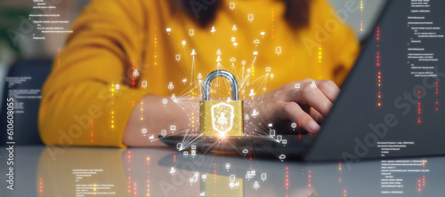 Cybersecurity technology concept. A person is using a computer with a padlock as a data privacy shield against digital threats. Protect hardware, software and applications connected to the Internet.