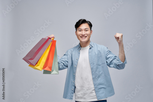 Excited man showing shopping bags and rejoicing from discounts,