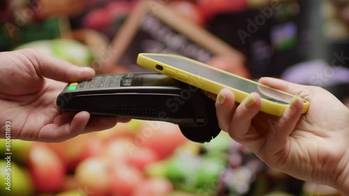 Hand Paying with Mobile Phone and NFC Terminal in Grocery Store. Online Payment in Supermarket.