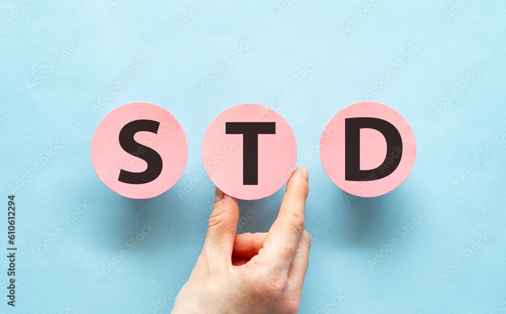 Hand holding pink cards with the word STD, Medical Concept.