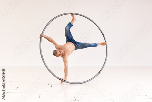 Acrobat performing stunt with cyr wheel