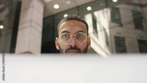 Professional male executive using a laptop in a building lobby