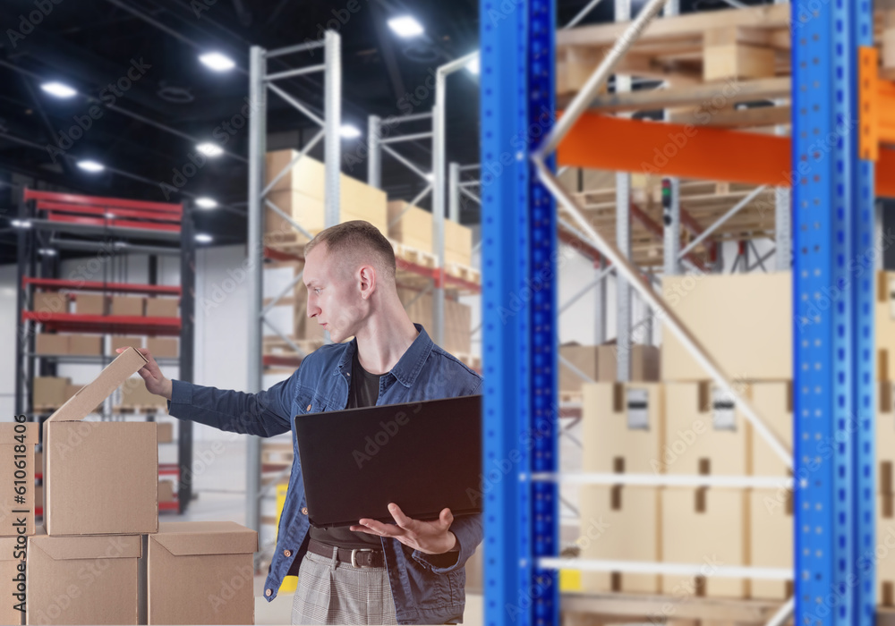 Businessman in warehouse. Man with laptop and boxes. Businessman inspects goods. Entrepreneur guy. Business owner in workplace. Warehouse shelves with boxes around man. Guy looking at parcels Businessman in warehouse. Man with laptop and boxes. Businessman inspects goods. Entrepreneur guy. Business owner in workplace. Warehouse shelves with boxes around man. Guy looking at parcels