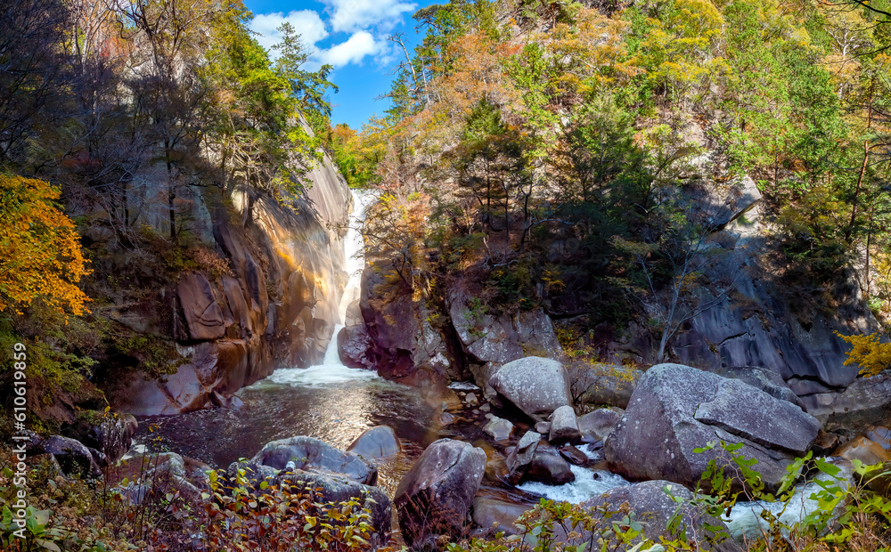 Obraz premium Regions of Japan. Kofu park. Waterfall in rocky area. Autumn landscape. Kofu national park. Nature of Japan in sunny weather. Japanese rocks are covered with trees. Maizuru castle park. Tour in Japan