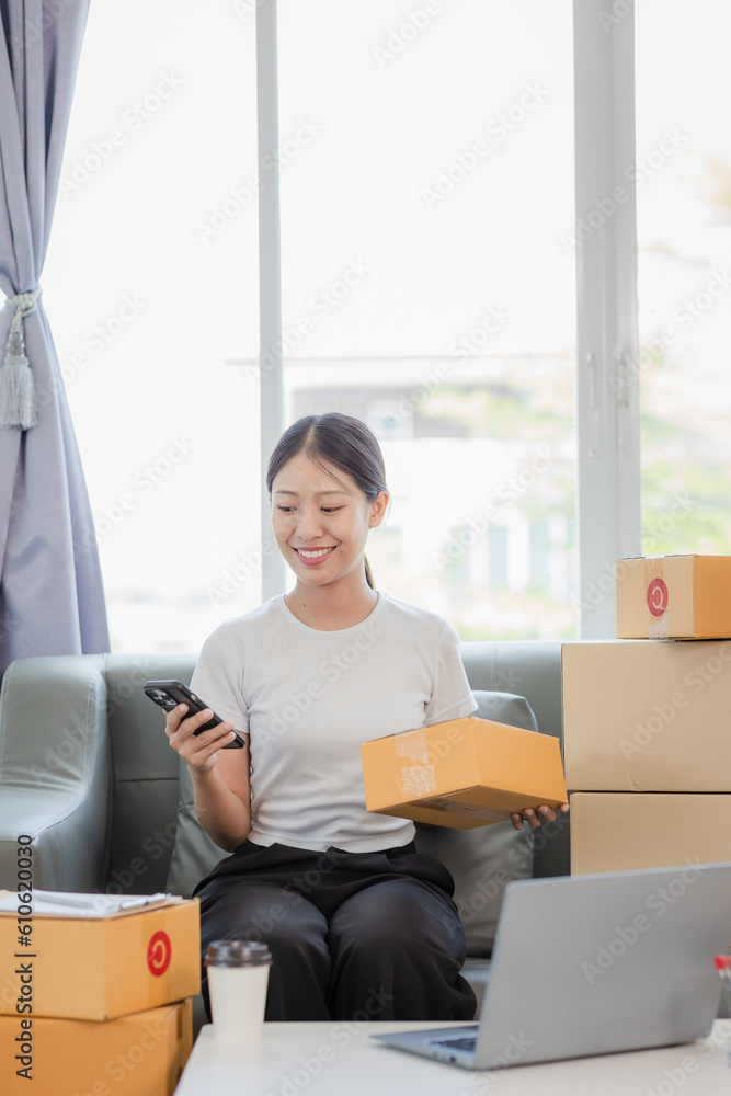 Starting a Small Business Entrepreneur Freelance Asian woman who is happy to work using a laptop with a box Cheerful successful online marketing packaging box and send SME concept Starting a Small Business Entrepreneur Freelance Asian woman who is happy to work using a laptop with a box Cheerful successful online marketing packaging box and send SME concept