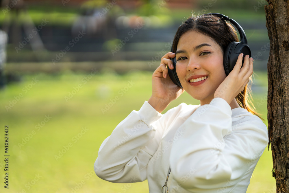 Portrait of smiling beauty asian woman happy and relax listening to music with headphones and singing, happy calm, resting ,good healthy, podcast, sound audio, listen online song at green park Portrait of smiling beauty asian woman happy and relax listening to music with headphones and singing, happy calm, resting ,good healthy, podcast, sound audio, listen online song at green park
