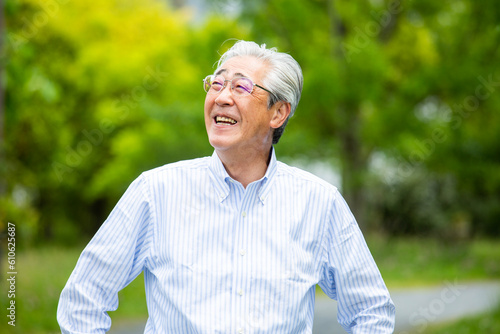上品な日本人ミドル男性のポートレート、新緑の屋外で撮影