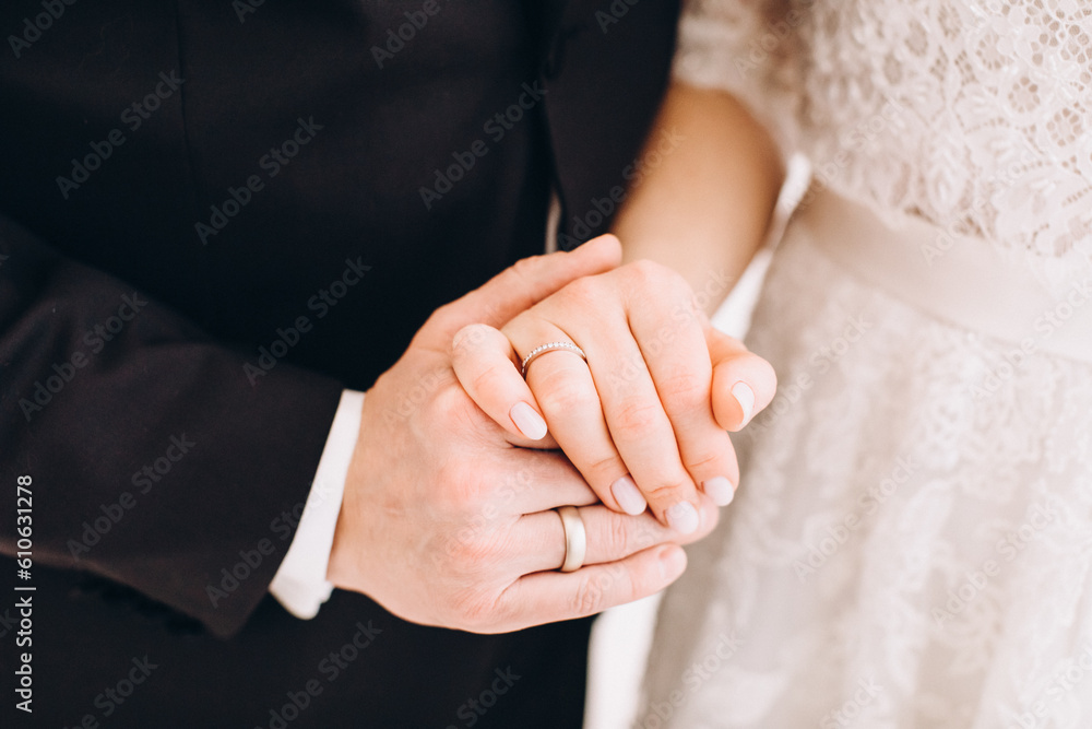 Wedding. The groom in a black suit and the bride in a white dress holding hands Wedding. The groom in a black suit and the bride in a white dress holding hands